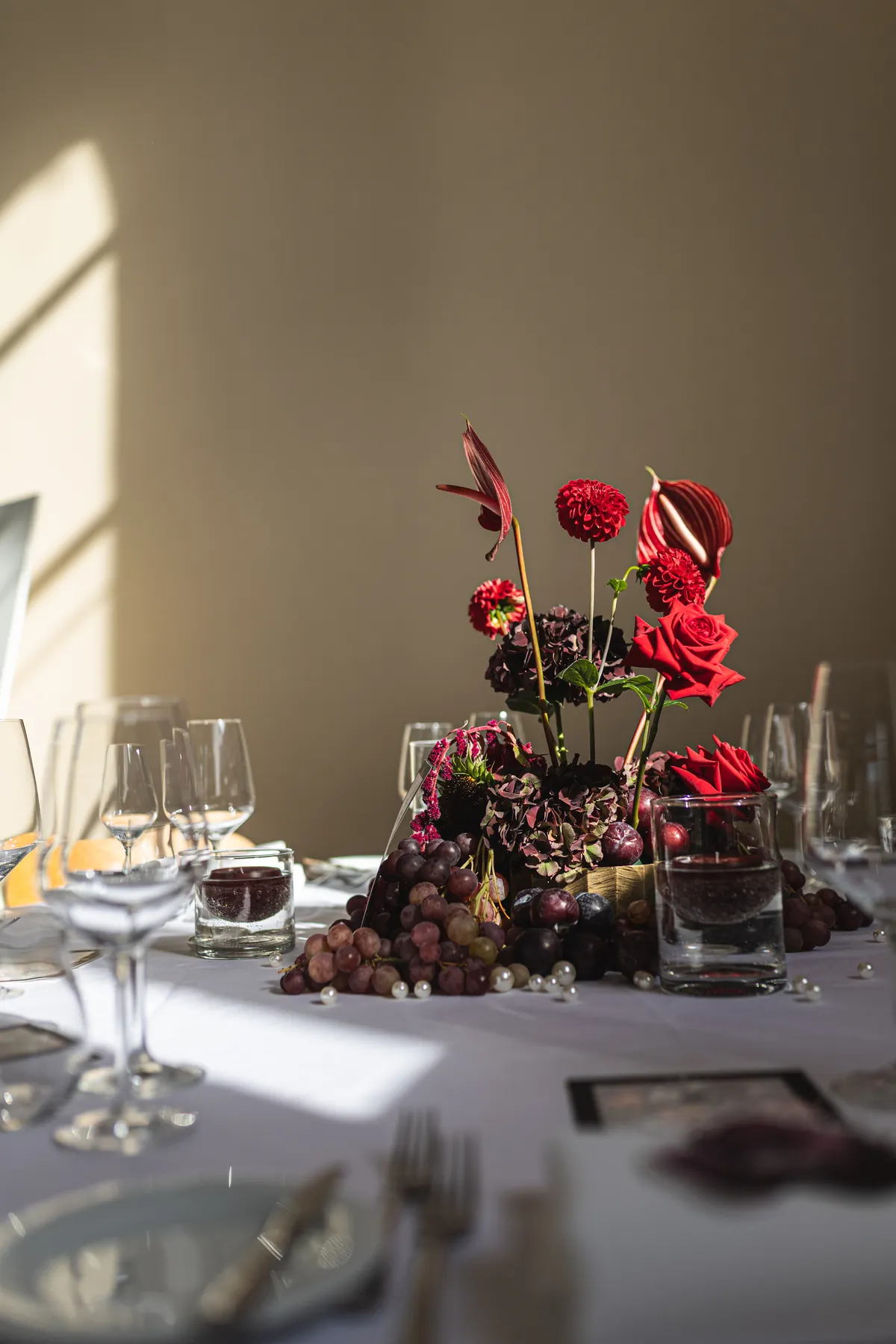 Gedeckter Tisch mit roten Blumen im Loft