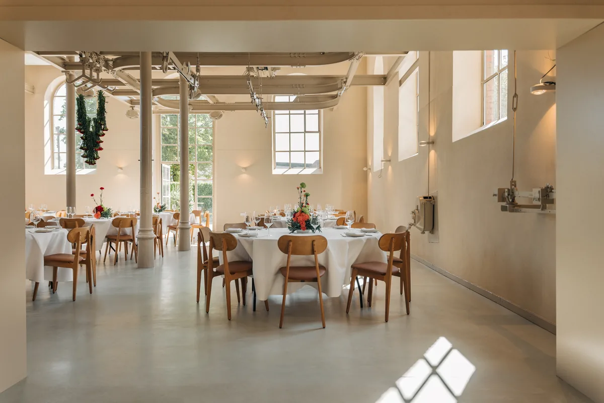 Blick durch den Durchgang ins helle Loft mit gedeckten Tischen