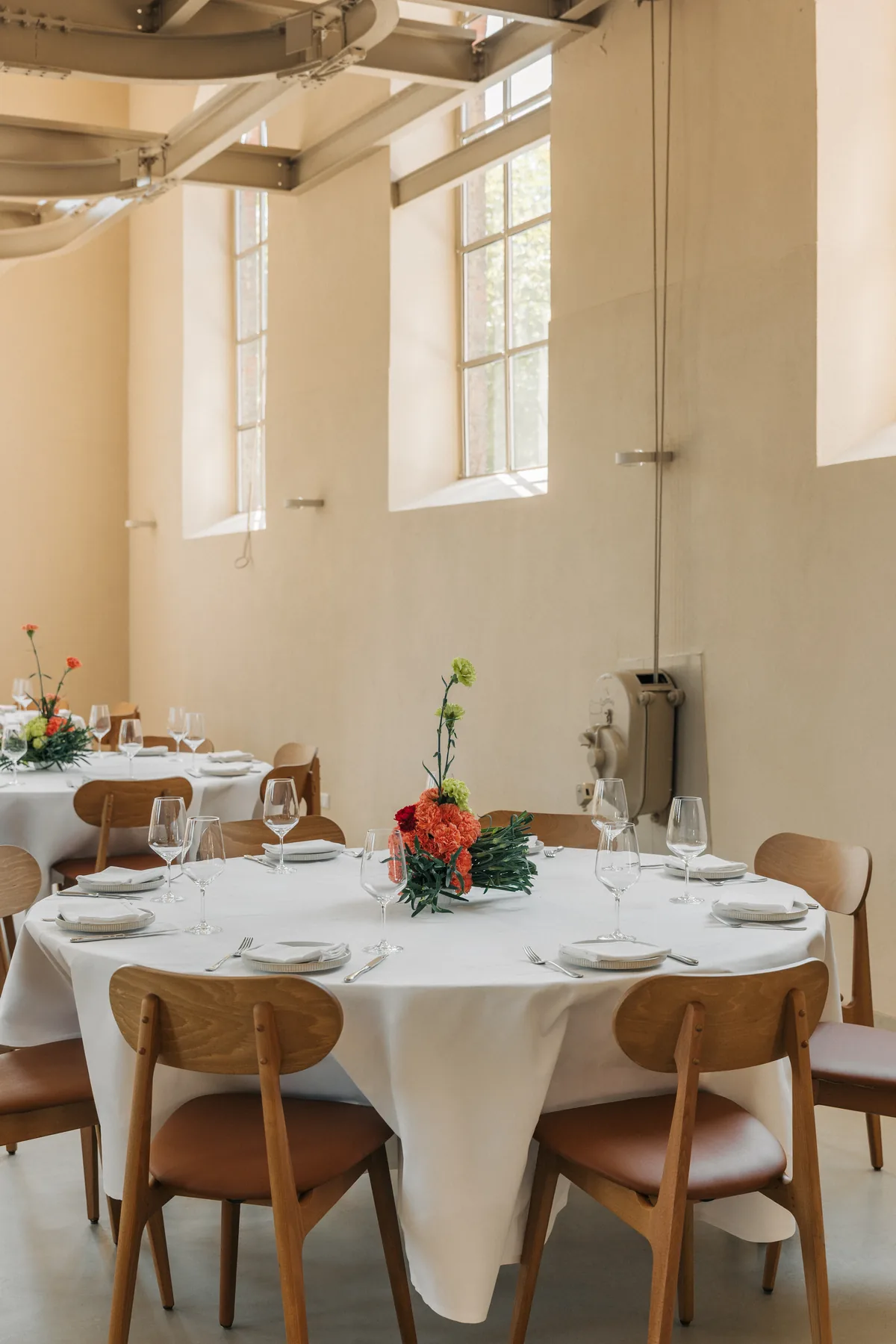 Runder Tisch mit Blumenschmuck im hohen Raum