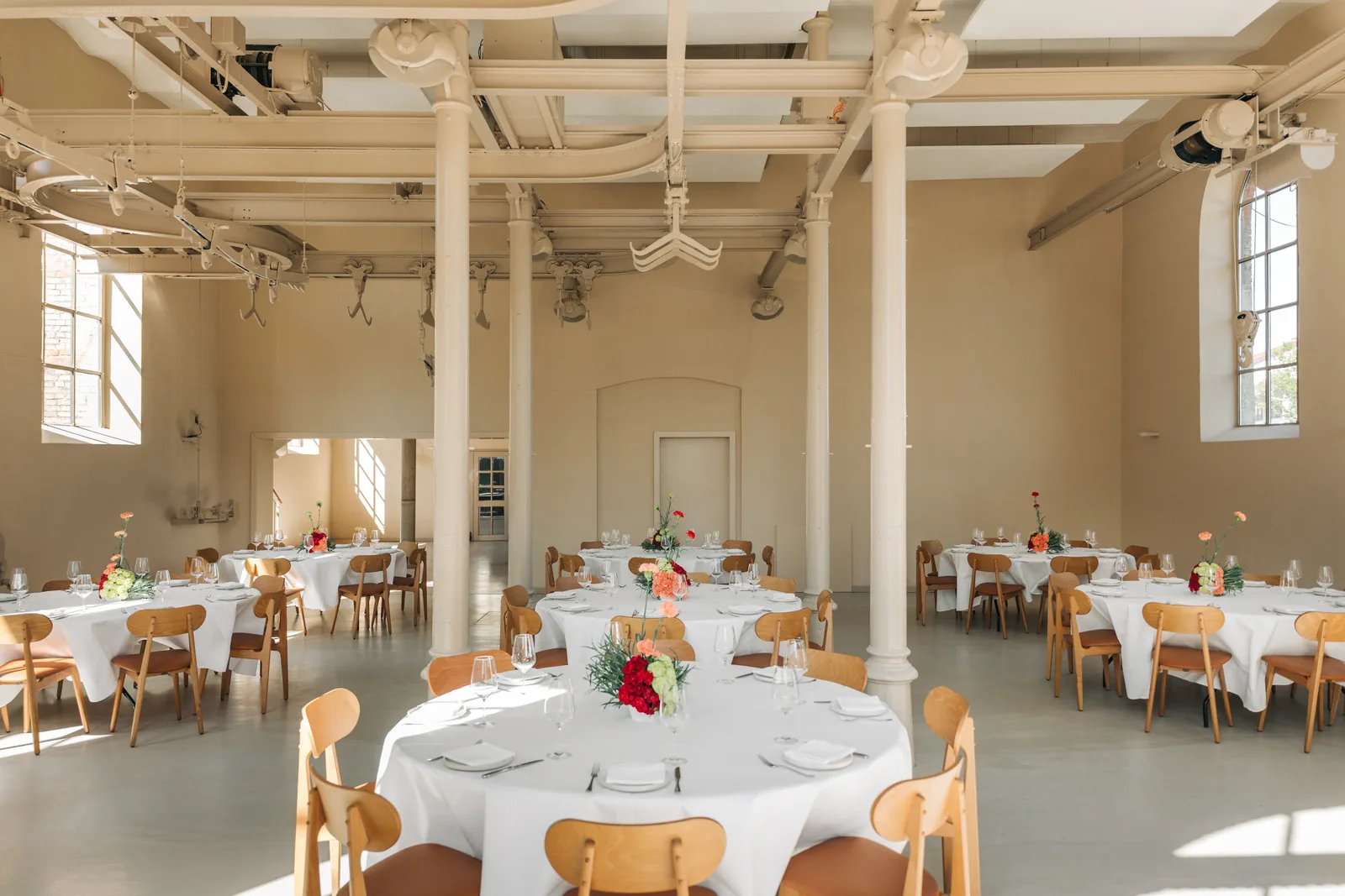 Loft mit runden Tischen und Blumenschmuck