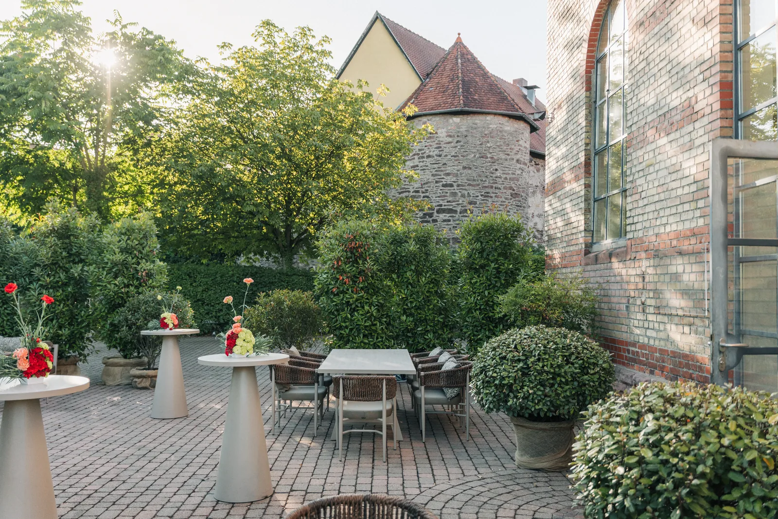 Sonnige Terrasse mit Olivenbäumen und Lounge-Möbeln