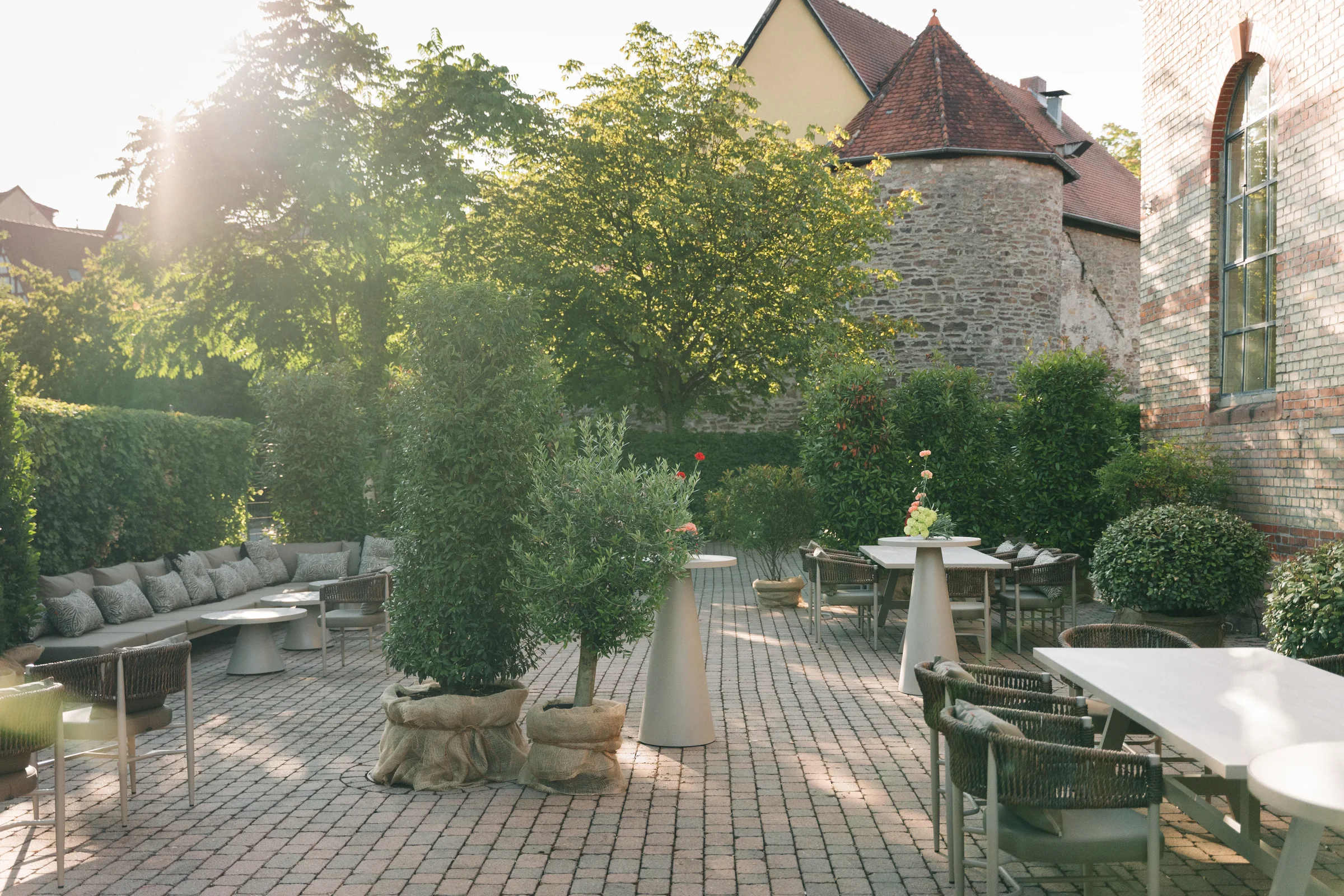 Terrasse mit Sofa-Lounge, Olivenbäumen und Steinturm
